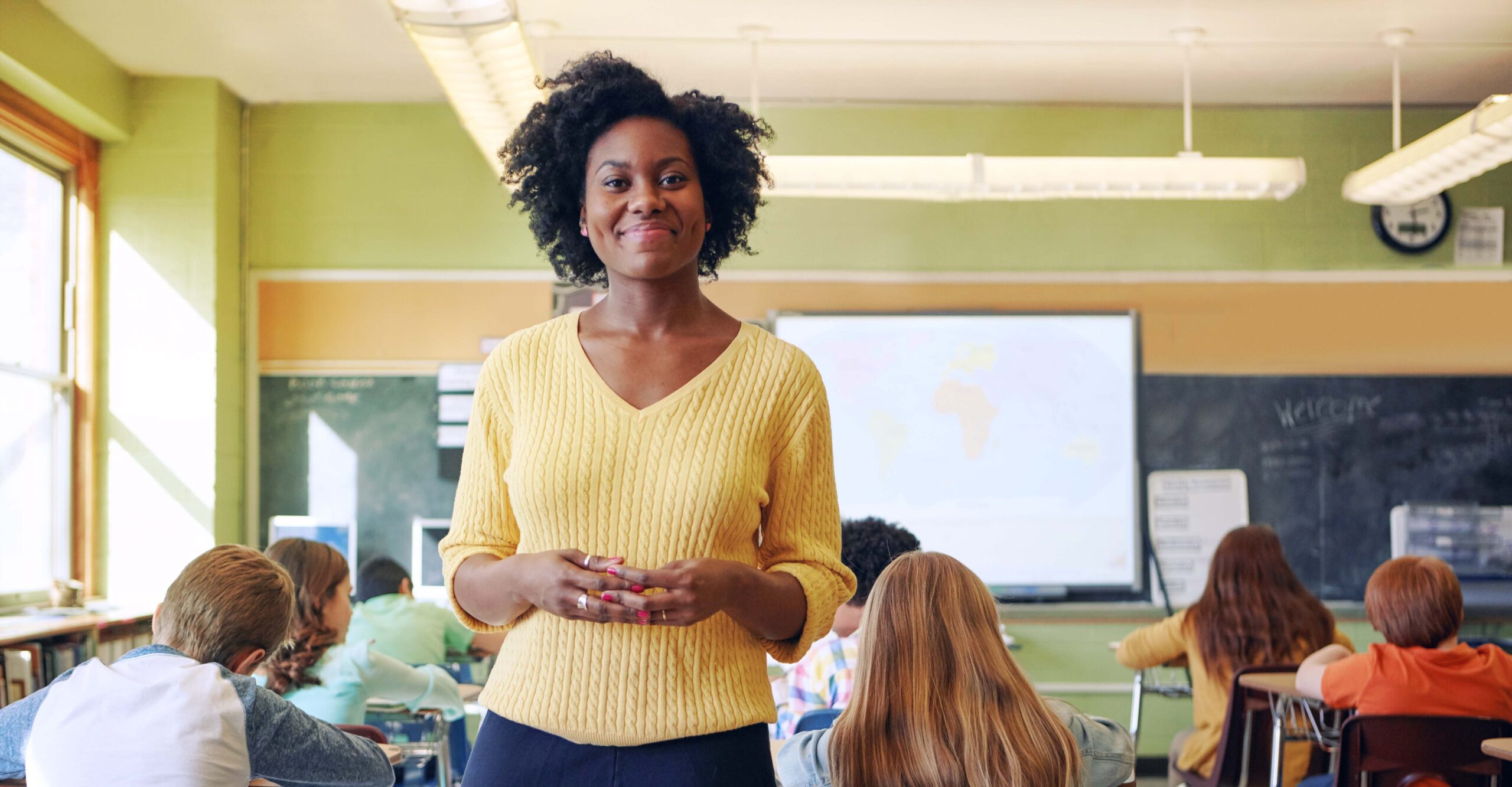 Portrait, teacher and black woman with students learning in classroom. Education, scholarship and happy, proud and young female educator with children ready for studying or knowledge in middle school